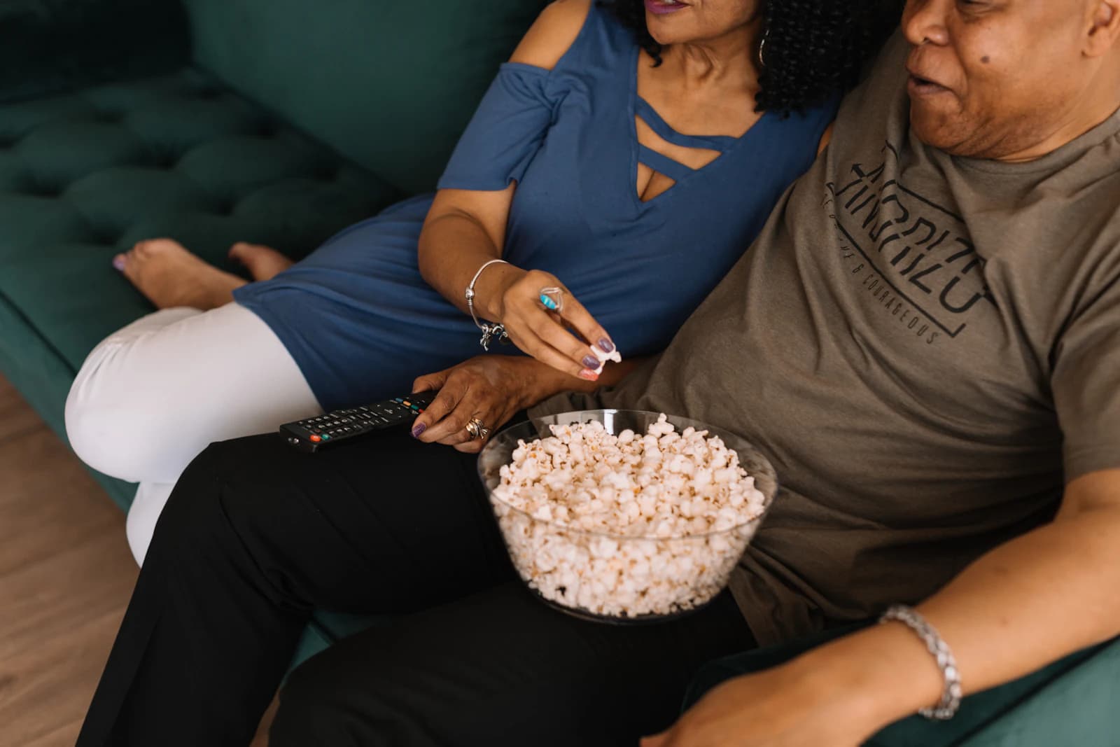 Par som delar popcorn framför TV:n