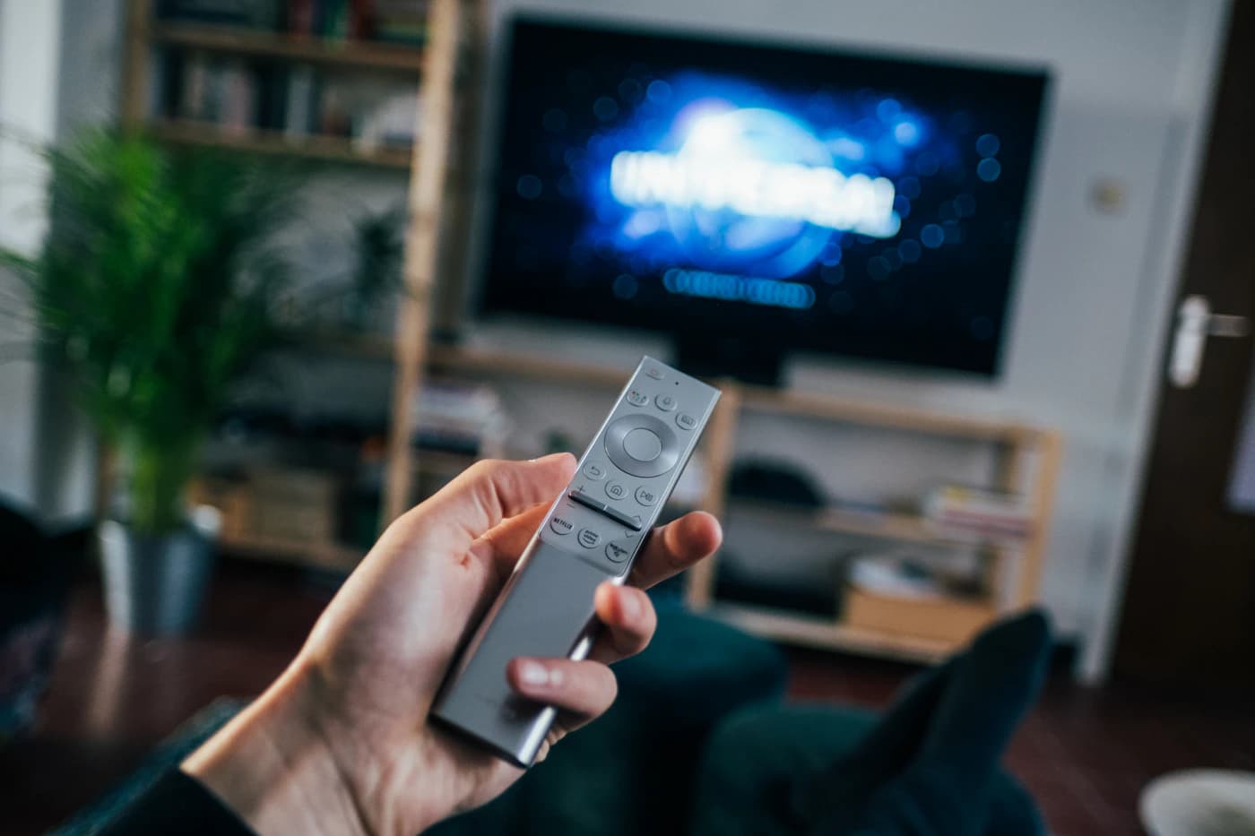 Person som håller en fjärrkontroll framför TV:n