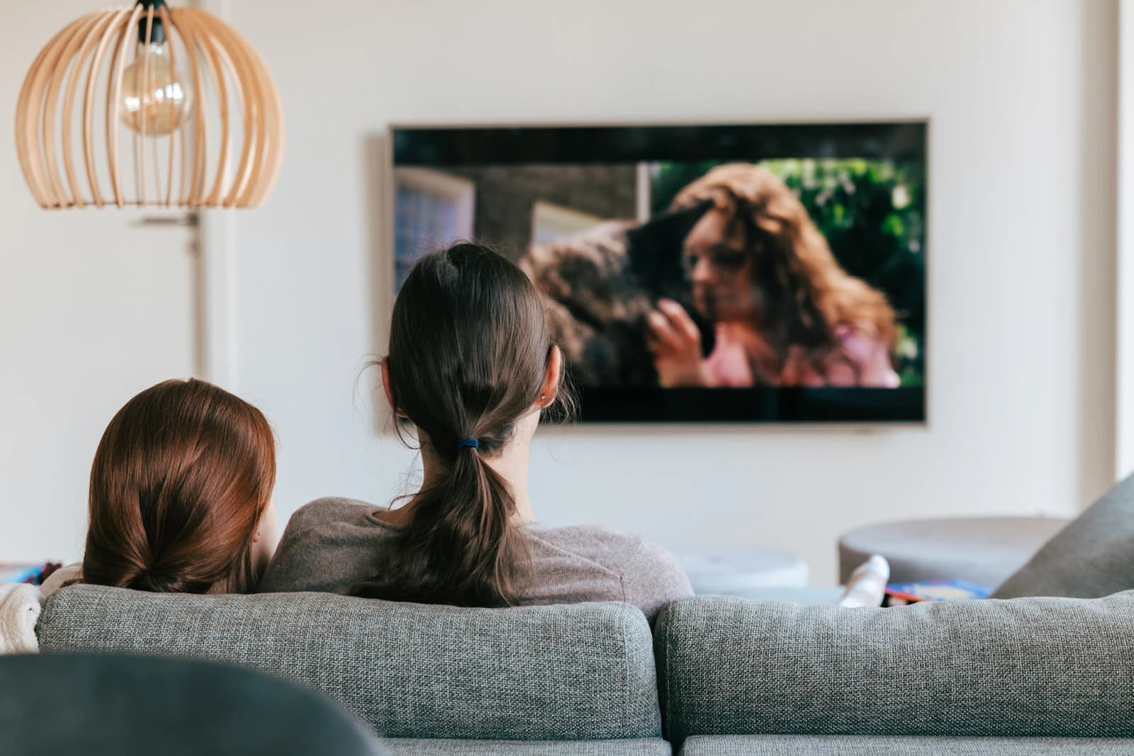 Två vänner som ser på TV i soffan